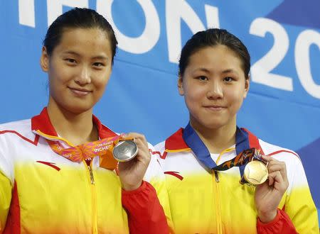 Gold medallist Chen Xinyi (R) of China and her compatriot, silver medallist Lu Ying, pose on the podium at the women's 100m butterfly final award ceremony at the Munhak Park Tae-hwan Aquatics Center during the 17th Asian Games in Incheon September 23, 2014. REUTERS/Tim Wimborne