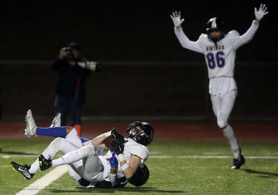 North Kitsap's Caleb Callahan scores a touchdown as he's brought down by Olympic's Malachi Hampton in October 2022.