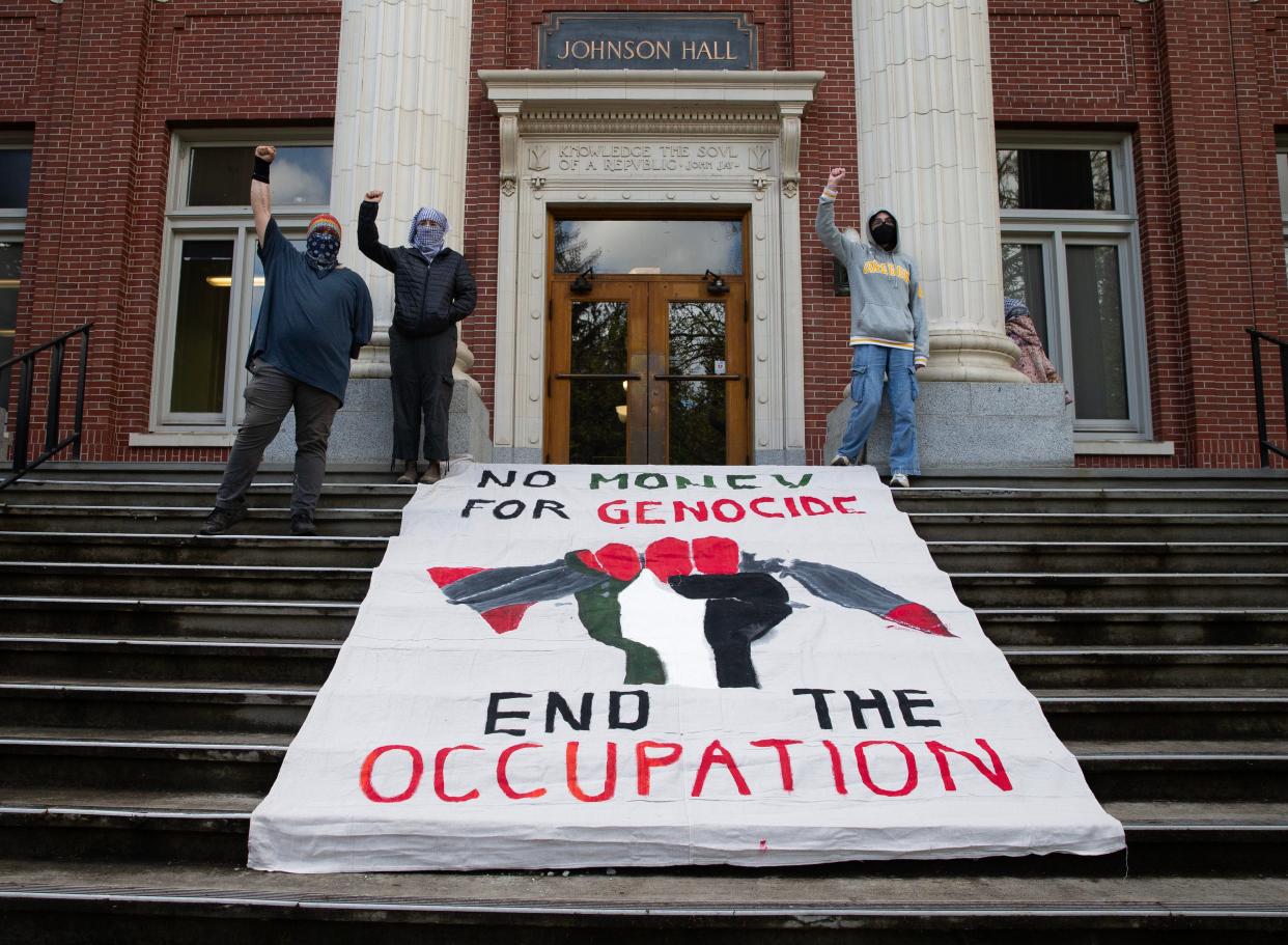 Pro-Palestinian protesters lay a banner on the steps of Johnson Hall at the University of Oregon campus in support of a cease fire in Gaza.