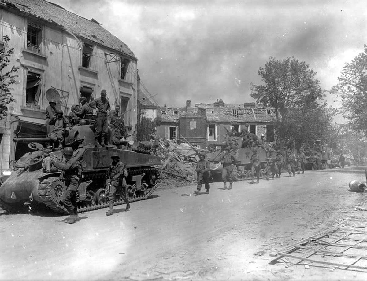 American armoured and infantry forces pass through the Normandy town of Coutances during Operation Cobra (US National Archives)
