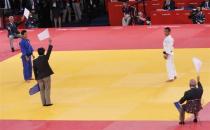 CROWD REVERSES DECISIONS: The referee and judges hold up white flags to indicate Japan's Masashi Ebinuma (white) as the new winner in the men's —66kg quarter— final judo match against South Korea's Cho Jun-Ho (blue) at the London 2012 Olympic Games July 29, 2012.