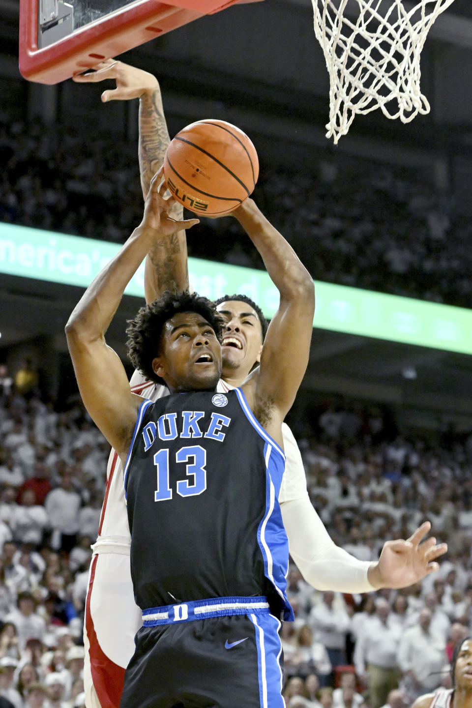 Duke forward Sean Stewart (13) shoots in front of Arkansas forward Jalen Graham (11) during the first half of an NCAA college basketball game Wednesday, Nov. 29, 2023, in Fayetteville, Ark. (AP Photo/Michael Woods)