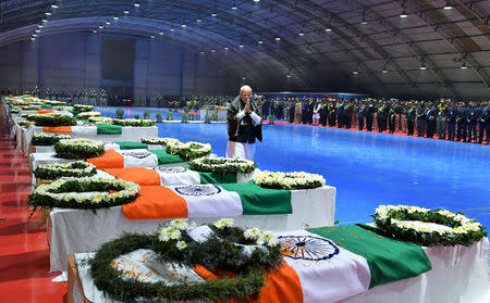 India's Prime Minister Narendra Modi pays tribute as he walks next to the coffins containing the remains of Central Reserve Police Force (CRPF) personnel who were killed after a suicide bomber rammed a car into a bus carrying them in south Kashmir on Thursday, at Palam airport in New Delhi, India, February 15, 2019. India's Press Information Bureau/Handout via REUTERS