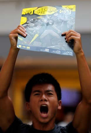 An anti-government protester holds a placard as he chant slogans at Olympian City 2 shopping mall in Hong Kong