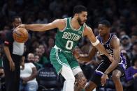 Boston Celtics' Jayson Tatum (0) keeps the ball away from Sacramento Kings' De'Aaron Fox (5) during the first half of an NBA basketball game Friday, April 5, 2024, in Boston. (AP Photo/Michael Dwyer)