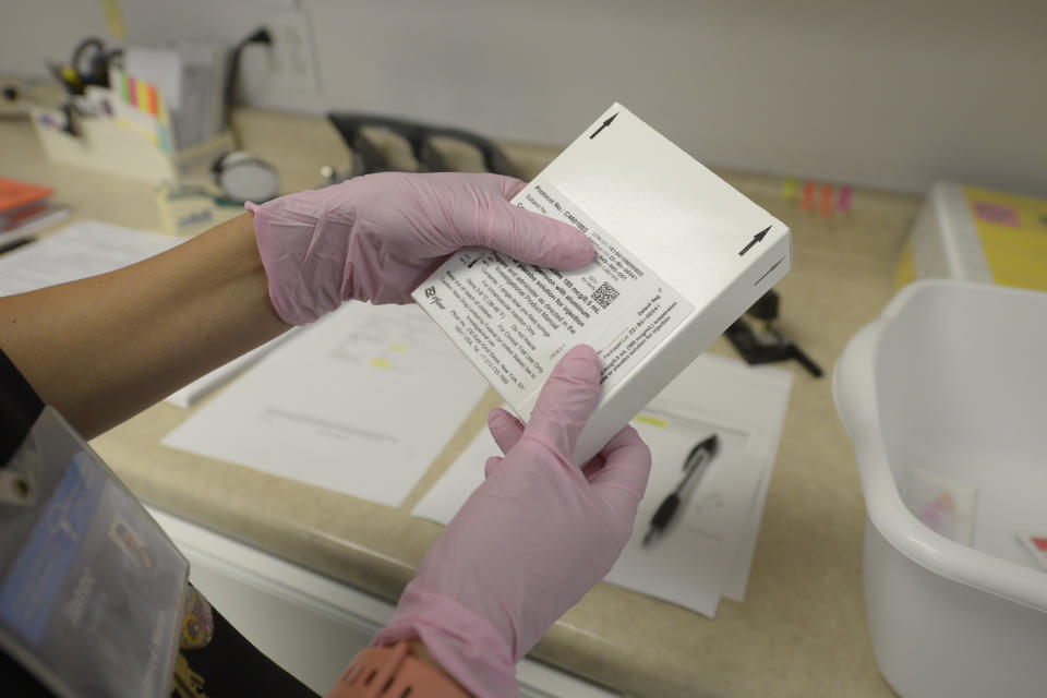 Away from volunteers participating in a new Lyme disease vaccine trial, registered nurse Janae Roland, prepares either the vaccine or a placebo at the Altoona Center for Clinical Research, Friday, Aug. 5, 2022, in Duncansville, Pa. The Centers for Disease Control and Prevention cites insurance records suggesting 476,000 people are treated for the the tick-borne disease in the U.S. each year. (AP Photo/Gary M. Baranec)