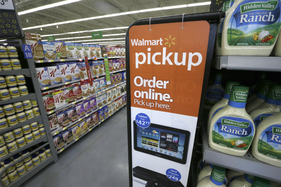 A sign encouraging customers to order grocery items online and pick them up at a store is displayed at a Wal-Mart Neighborhood Market in Bentonville, Ark., Thursday, June 4, 2015. (AP Photo/Danny Johnston)