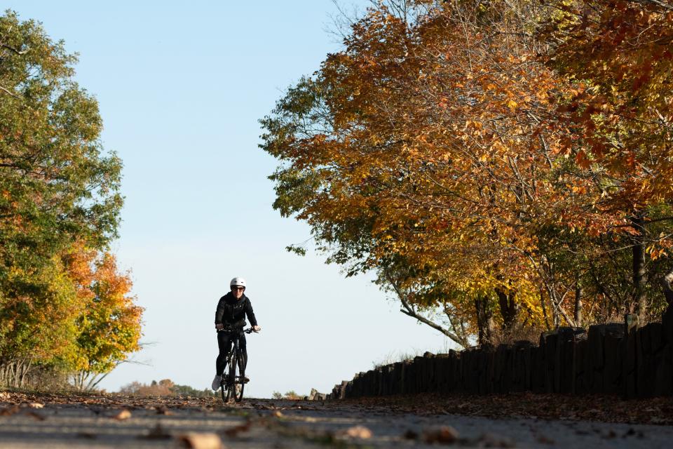 A woman rides her bike along a path at the State Line Lookout at Palisades Interstate Parkway in Alpine, NJ on Wednesday Oct. 25, 2023.