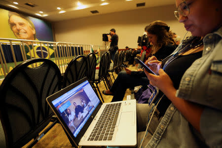 Journalists follow a Facebook Live of Jair Bolsonaro, far-right lawmaker and presidential candidate of the Social Liberal Party (PSL), in Rio de Janeiro, Brazil October 7, 2018. REUTERS/Sergio Moraes