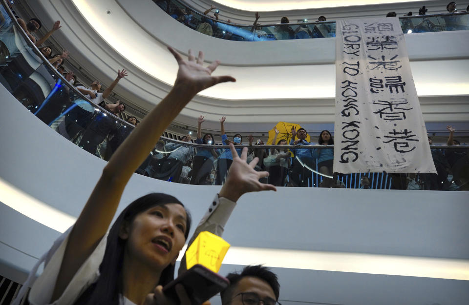 Demonstrators sing a theme song written by protestors "Glory to Hong Kong" at the Times Square shopping mall in Hong Kong, Thursday, Sept. 12, 2019. Thousands of people belted out a new protest song at Hong Kong's shopping malls in an act of resistance that highlighted the creativity of demonstrators in their months-long fight for democratic freedoms in the semi-autonomous Chinese territory. (AP Photo/Vincent Yu)