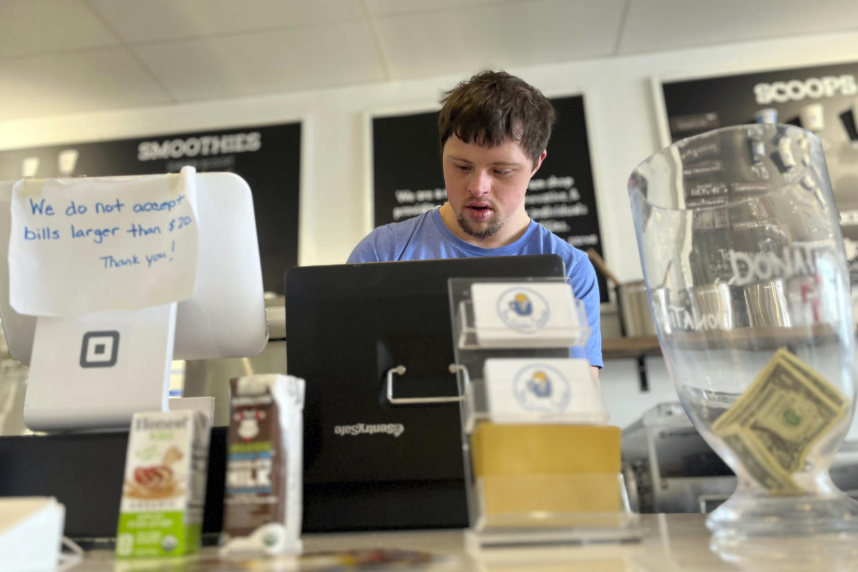 Patrick Chapman, 27, prepares for customers Thursday, March 2, 2023, at The Golden Scoop, an Overland Park, Kan., ice cream and coffee shop that employs workers with developmental disabilities, paying them more than minimum wage. But some disabled workers employed at so-called sheltered workshops are earning far less than minimum wage, an issue that has captured the attention of lawmakers in the state. Disability rights advocates say the practice is discriminatory and more than a dozen states have banned such wages. (AP Photo/Heather Hollingsworth)