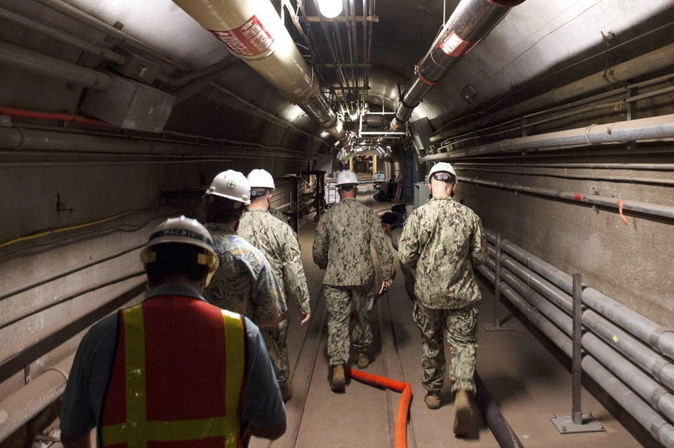 FILE - In this photo provided by the U.S. Navy, Rear Adm. John Korka, Commander, Naval Facilities Engineering Systems Command (NAVFAC), and Chief of Civil Engineers, leads Navy and civilian water quality recovery experts through the tunnels of the Red Hill Bulk Fuel Storage Facility, near Pearl Harbor, Hawaii, on Dec. 23, 2021. A trial is set to start on Monday, April 29, 2024, in a case surrounding the 2021 leaked jet fuel into the Navy water system that serves 93,000 people on and around the Pearl Harbor base. There are 17 people suing the United States over the leak and continuing health problems they argue are tied to the tainted water. (Mass Communication Spc. 1st Class Luke McCall/U.S. Navy via AP, File)