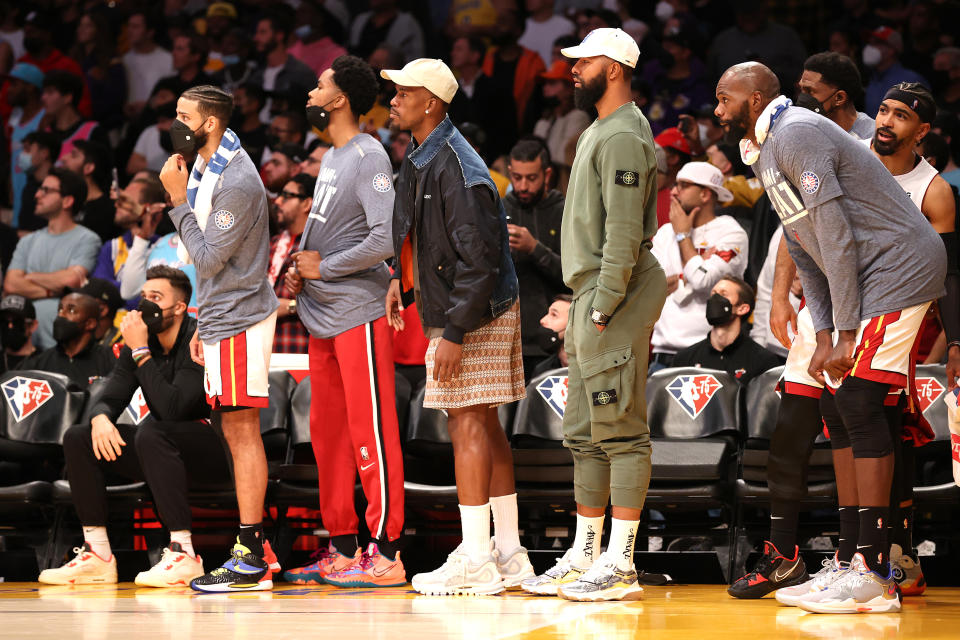 Jimmy Butler stands at the bench in street clothes.