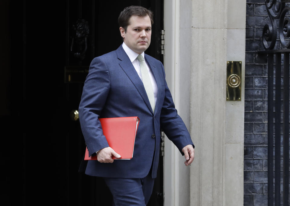 Britain's Housing Secretary Robert Jenrick leaves Downing Street after a meeting in London, Wednesday, March 18, 2020. For most people, the new coronavirus causes only mild or moderate symptoms, such as fever and cough. For some, especially older adults and people with existing health problems, it can cause more severe illness, including pneumonia. (AP Photo/Kirsty Wigglesworth)