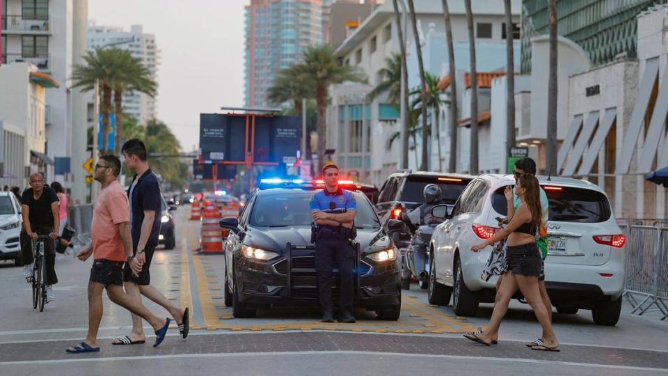 A police officer stands watch on Collins Avenue during spring break on Miami Beach, Florida, on Saturday, March 9, 2024.