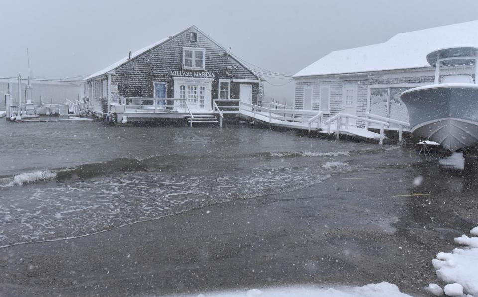 Storm surge waves flood into the parking lot at Millway Marina along Barnstable Harbor at high tide Saturday morning.