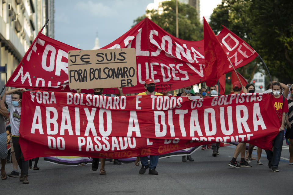 Demonstrators hold a banner with a message that reads in Portuguese: "Down with the Dictatorship," during a protest against the Brazilian President Jair Bolsonaro coinciding with the anniversary of the 1964 military coup that established a decades-long dictatorship, in Rio de Janeiro, Brazil, Wednesday, March 31, 2021. The leaders of all three branches of Brazil’s armed forces have jointly resigned following Bolsonaro’s replacement of the defense minister, that is causing widespread apprehension of a military shakeup to serve the president’s political interests. (AP Photo/Silvia Izquierdo)