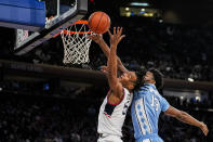 UConn guard Stephon Castle shoots at the basket over North Carolina forward Jalen Washington (13) during the first half of an NCAA college basketball game in New York, Tuesday, Dec. 5, 2023. (AP Photo/Peter K. Afriyie)