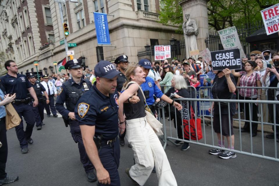 NYPD officers removing a woman at the Columbia protest. ZUMAPRESS.com