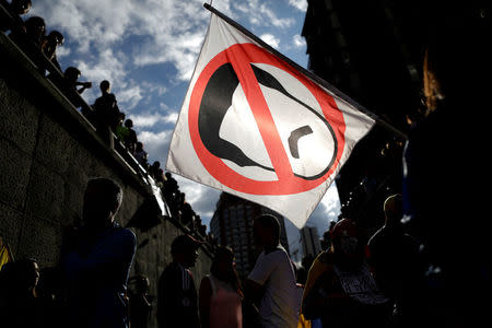 Opposition supporters carry a flag with a cartoon of Venezuela's President Nicolas Maduro while attending a rally to pay tribute to victims of violence during protests against Maduro's government in Caracas, Venezuela. REUTERS/Ueslei Marcelino