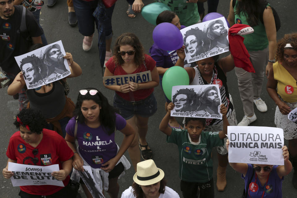 Women carry signs that read in Portuguese "Dictatorship Never Again" during a protest called "Women against Bolsonaro," in Brasilia, Brazil, on Saturday, Oct. 20, 2018. Women and left-wing militants held protests across the country against the right-wing presidential candidate Jair Bolsonaro. (AP Photo/Eraldo Peres)