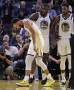 Golden State Warriors' Stephen Curry, left, grimaces as Eric Paschall (7) and Glenn Robinson III (22) watch, after Phoenix Suns' Aron Baynes fell onto Curry during the second half of an NBA basketball game Wednesday, Oct. 30, 2019, in San Francisco. Curry left the game. (AP Photo/Ben Margot)