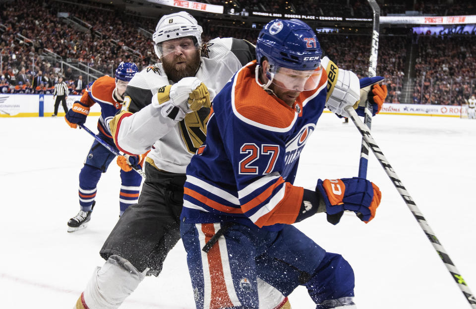 Vegas Golden Knights' Phil Kessel (8) and Edmonton Oilers' Brett Kulak (27) vie for the puck during the third period of an NHL hockey game Saturday, March 25, 2023, in Edmonton, Alberta. (Jason Franson/The Canadian Press via AP)