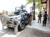 Afghan security forces keep watch near the site of an attack on a jail compound in Jalalabad