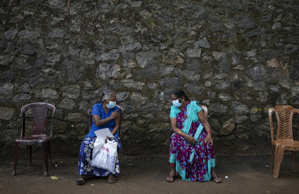 Sri Lankan women chat after getting inoculated against the coronavirus in Colombo, Sri Lanka, in August 2021. (AP Photo/Eranga Jayawardena)
