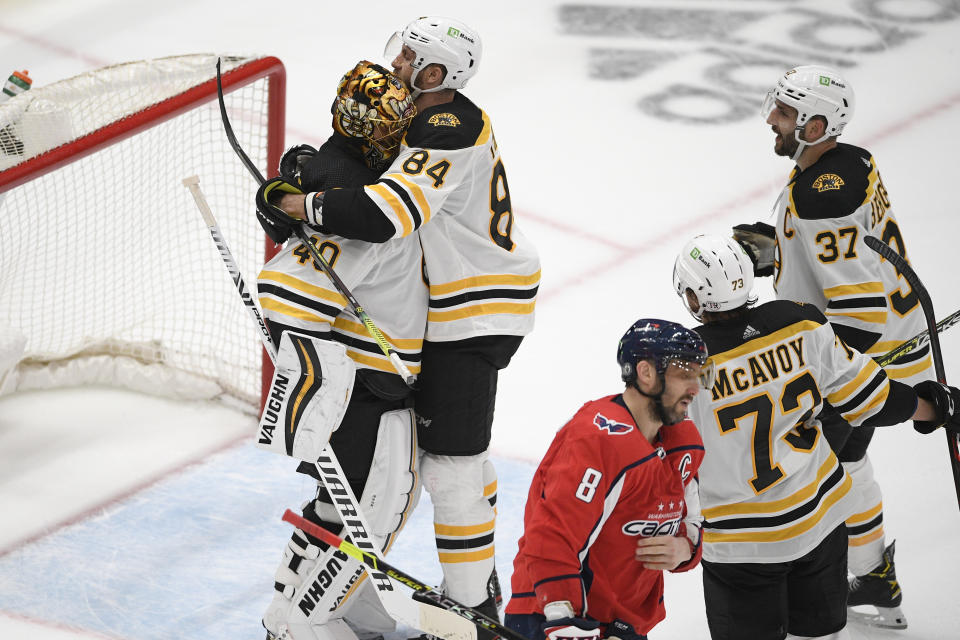 Boston Bruins goaltender Tuukka Rask (40) and defenseman Jarred Tinordi (84) celebrate after Game 5 of an NHL hockey Stanley Cup first-round playoff series as Washington Capitals left wing Alex Ovechkin (8) skates away, Sunday, May 23, 2021, in Washington. Also seen are Bruins center Patrice Bergeron (37) and defenseman Charlie McAvoy (73). The Bruins won 3-1. (AP Photo/Nick Wass)