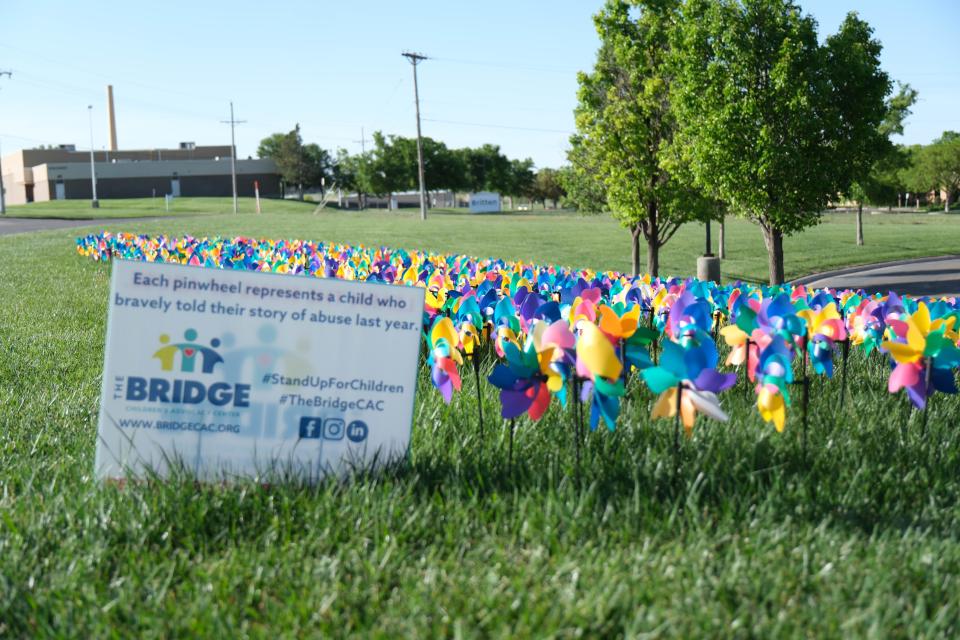 Pinwheels on Saturday representing the 1,023 children who received services from The Bridge Children's Advocacy Center are seen at the "Walk a Mile in Their Shoes,” a one-mile run/walk event at The Bridge Advocacy Center.