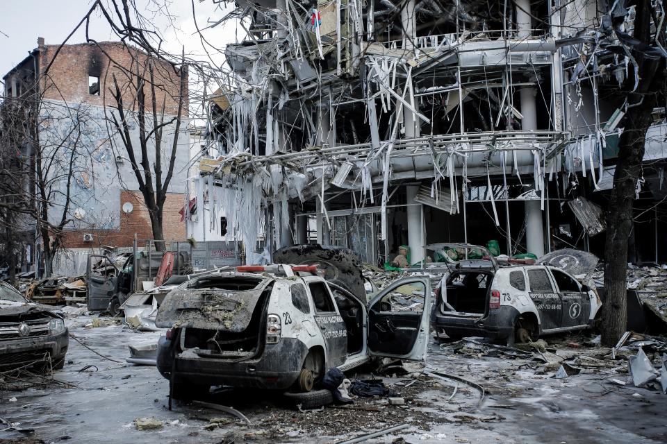 Damaged vehicles sit among debris in Kharkiv, Ukraine.