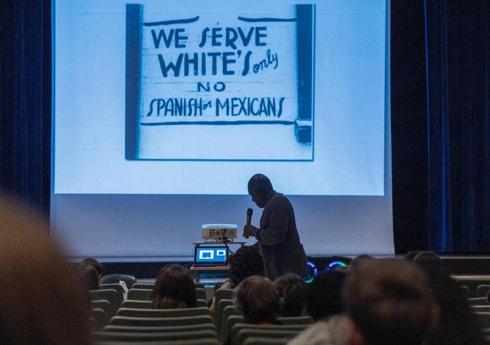 Marvin Dunn displays several historic images as he speaks during his presentation about racism and discrimination.