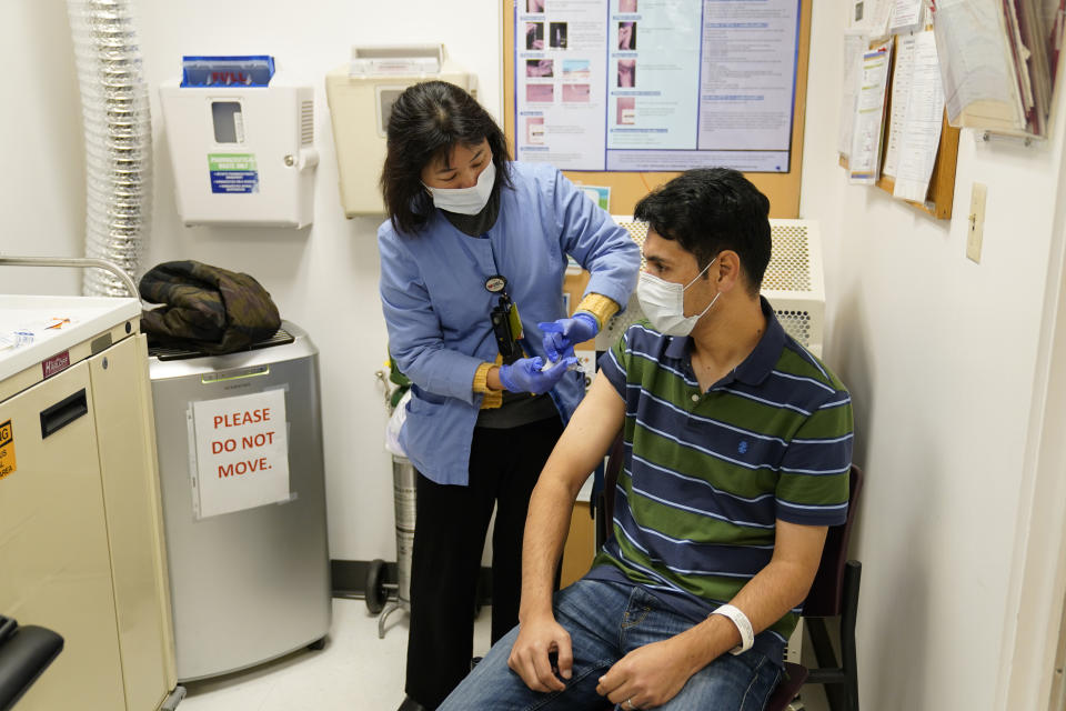 A newly arrived refugee from Afghanistan receives a vaccination from clinical nurse Catherine Pham at the Valley Health Center TB/Refugee Program in San Jose, Calif., Thursday, Dec. 9, 2021. The staff of Silicon Valley's decades-old refugee health clinic may not all speak the language of the Afghan refugees starting new lives in the San Francisco Bay Area. But they know the anxiety and stress of newcomers who fled war and chaos to end up in a country where they don't speak the language and everything is different. (AP Photo/Eric Risberg)