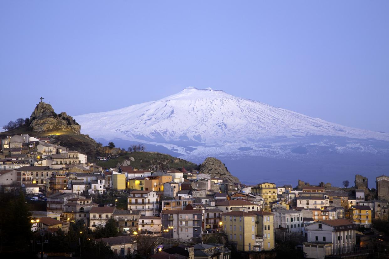 View of the village of San Teodoro and Etna volcano on background. Sicily, Italy.