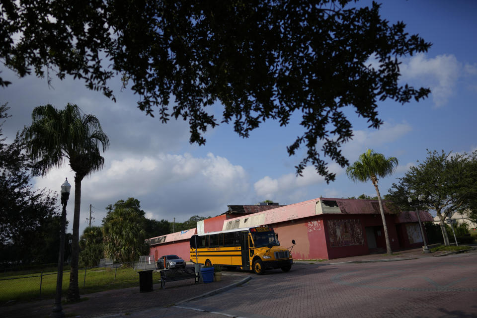 A school bus drives past the building which once housed Club Eaton, which opened during segregation and in its heyday became a venue for the country's most celebrated Black musicians, Thursday, Aug. 24, 2023, in Eatonville, Fla. (AP Photo/Rebecca Blackwell)