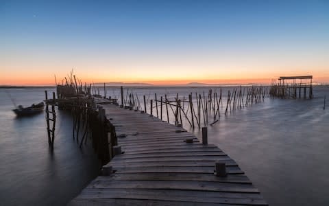 Sunset at Palafito Pier of Carrasqueira Natural Reserve - Credit: Getty Images