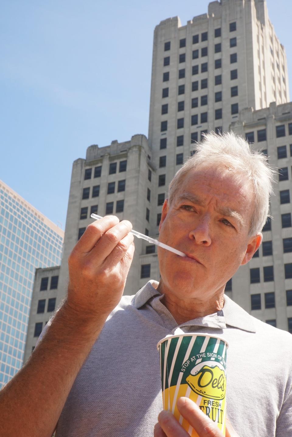 Journal columnist Mark Patinkin tries to drink a Del’s Lemonade with a straw in Kennedy Plaza in 2019.