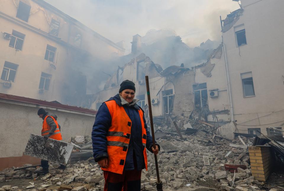 Municipal workers remove debris outside a damaged local railway administration headquarters in Donetsk this morning (Reuters)