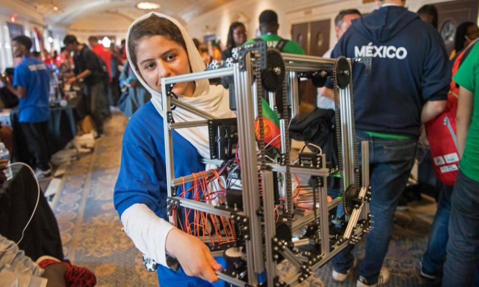 A member of the Afghani all-girls robotics team carries her team’s robot.