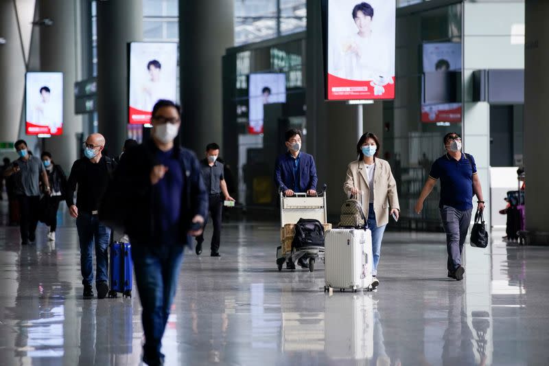 FILE PHOTO: People wearing face masks are seen at Hongqiao International Airport in Shanghai