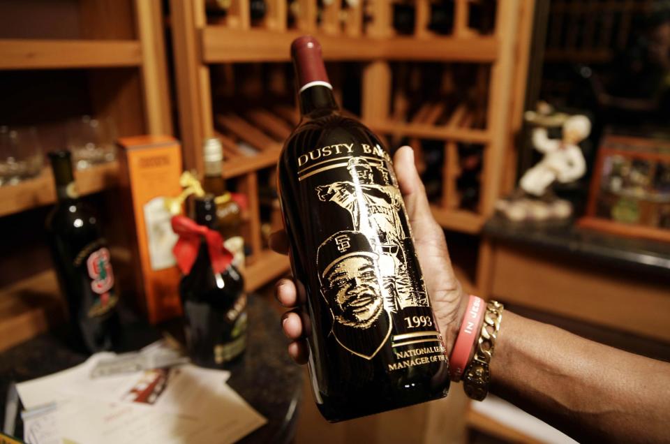 In this March 13, 2014 photo, Dusty Baker holds a specially etched bottle of wine given to him by Gary Matthews in the wine cellar of his home in Granite Bay, Calif. The bottle honors Baker being named the National League Manager of the Year in 1993. Out of uniform for the first time since taking 2007 off between managerial jobs with the Cubs and Reds, Baker is not slowing down much from his pressure-packed days in the dugout. (AP Photo/Eric Risberg)