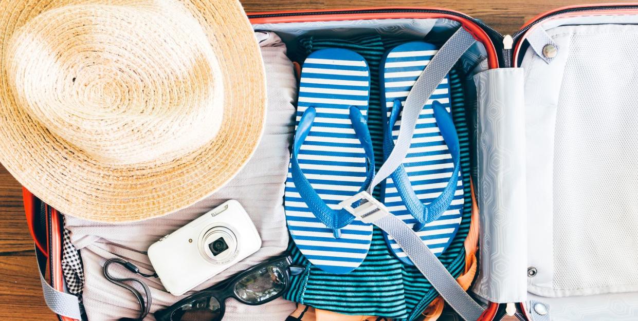 Directly Above Shot Of Personal Accessories In Suitcase On Hardwood Floor