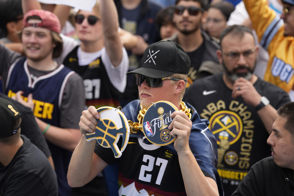 A fan holds up medallions during a rally and parade to mark the Denver Nuggets first NBA basketball championship on Thursday, June 15, 2023, in Denver. (AP Photo/David Zalubowski)