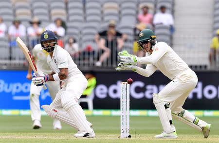 India's captain Virat Kohli plays a shot watched by Australia's captain and wicketkeeper Tim Paine on day two of the second test match between Australia and India at Perth Stadium in Perth, Australia, December 15, 2018. AAP/Dave Hunt/via REUTERS