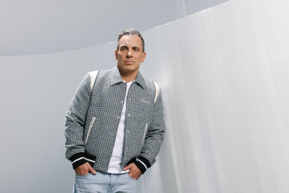 Man posing next to a white wall