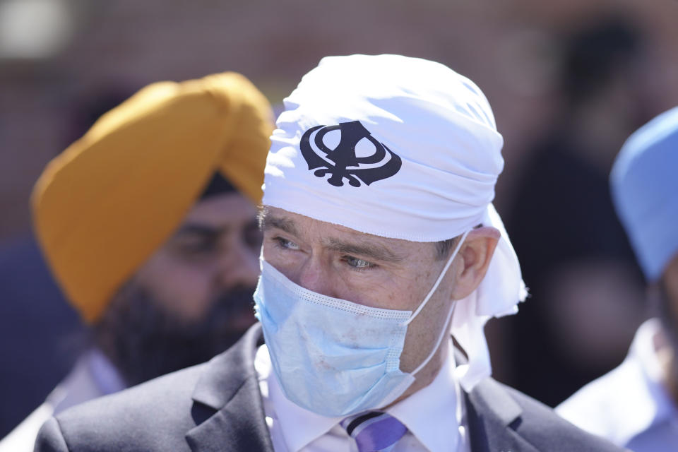 Sen. Todd Young, R-Ind., speaks with members of the Sikh Coalition at the Sikh Satsang of Indianapolis in Indianapolis, Saturday, April 17, 2021, for a commemoration of the victims of the shooting at a FedEx facility in Indianapolis that claimed the lives of four members of the Sikh community. A gunman killed eight people and wounded several others before taking his own life in a late-night attack at a FedEx facility near the Indianapolis airport. (AP Photo/AJ Mast)