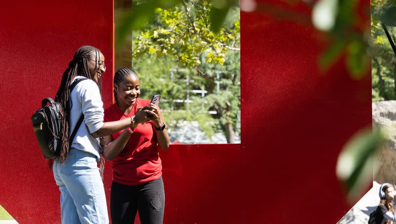 Left to right, Uchechi Unamma shows her phone to Juwon Adeyemo in front of the U on the University of Utah campus in Salt Lake City on Monday, Aug. 28, 2023. Both students are first-year graduate students from Nigeria.