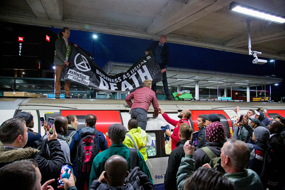 XR activists climb onto a train at London’s Canning Town station, prompting a standoff with commuters, on Oct. 17. | Extinction Rebellion