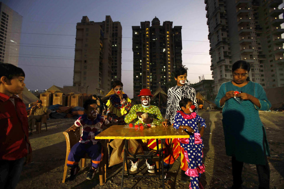 In this April 11, 2013 photo, clowns sell clown noses to children after a show at the Rambo Circus on the outskirts of Mumbai, India. Circuses around the world may struggle to compete with an ever-increasing array of entertainment options, but India’s once-widespread industry in particular has gone through cataclysmic changes. In the 1990s, there were 300 circuses operating throughout the country. That number has now dwindled to about 30, says circus manager John Matthew, and many of those are in financial trouble due to rising costs of renting field space, shrinking revenues and - crucially - two Supreme Court rulings that took away two of the industry’s main attractions. (AP Photo/Rafiq Maqbool)